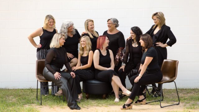 Group picture of stylists at Changes Hair Studio posing and smiling at each other