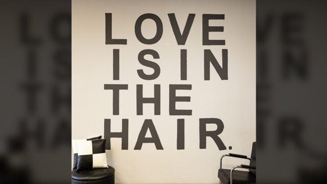 "LOVE IS IN THE HAIR" graphic on wall of Changes Hair Studio salon